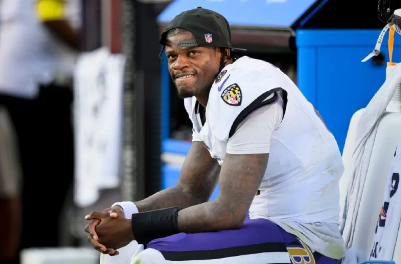 Lamar Jackson watches from the sideline in Ravens gear during a home game.