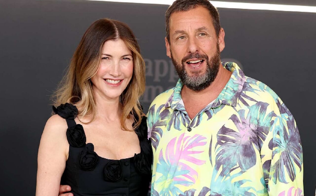 Adam Sandler and Jackie Sandler smiling together at a Hollywood event, celebrating their 22-year marriage.