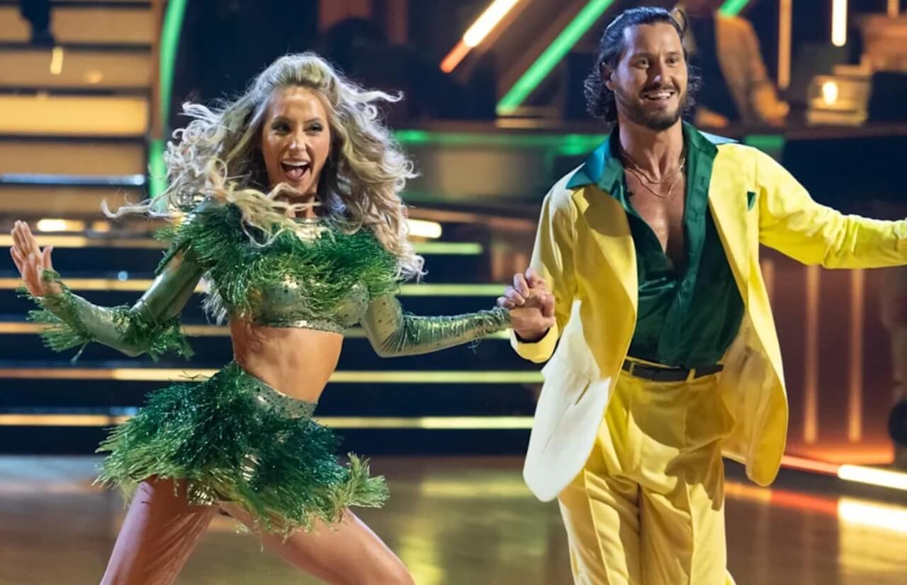 Alix Earle smiling and posing with Val Chmerkovskiy on the Dancing With the Stars stage during Season 34.