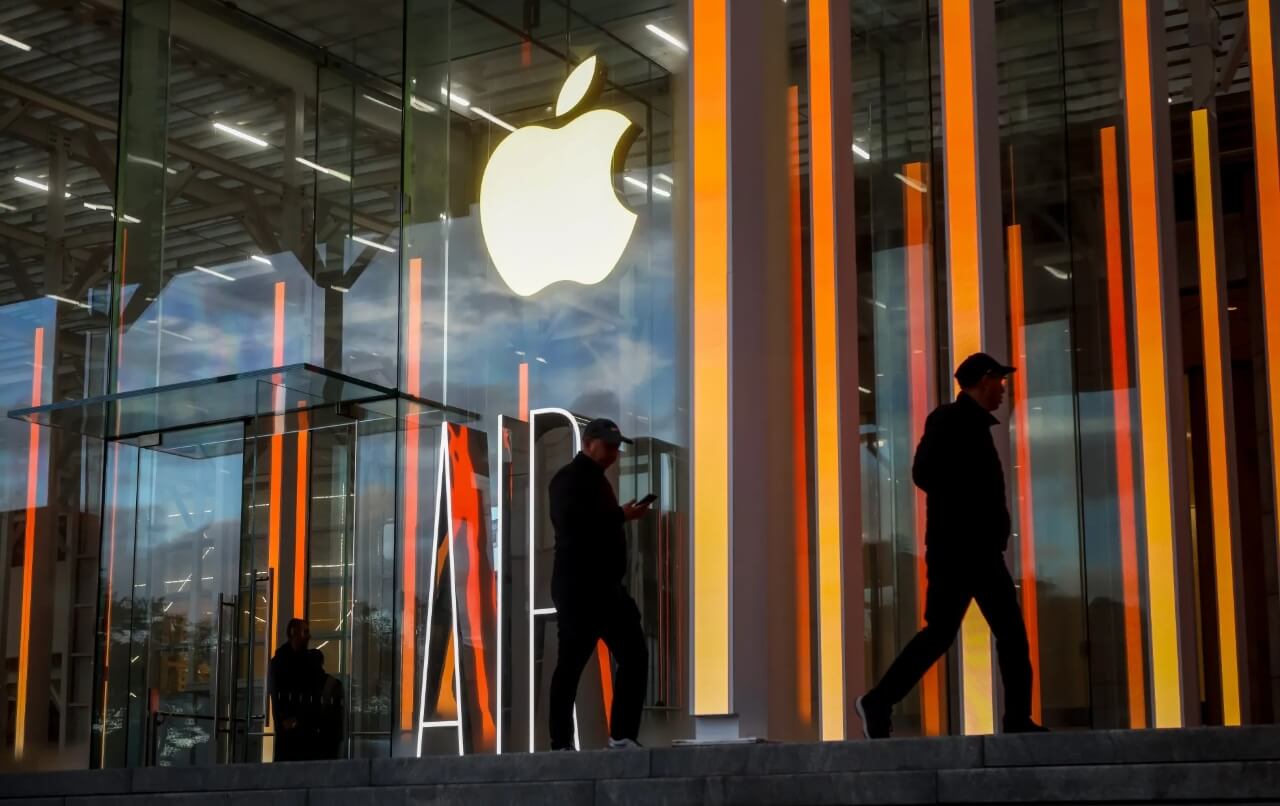 Apple corporate campus building with visitors walking near the entrance