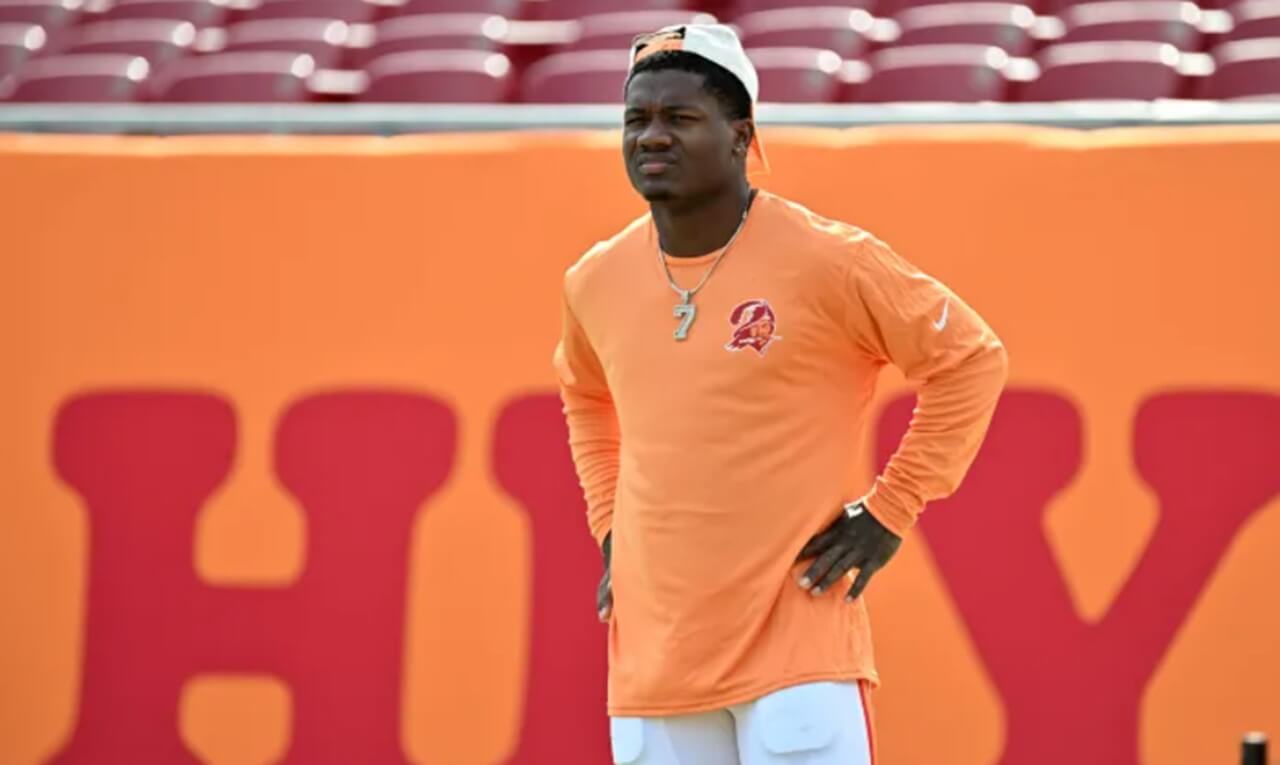 Chris Godwin and Bucky Irving watch from sideline during Buccaneers pregame warmups.