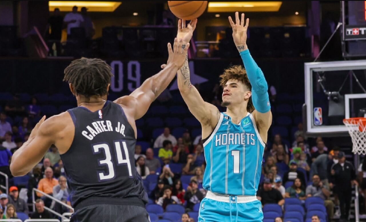 LaMelo Ball dribbles past Desmond Bane in Hornets vs Magic matchup.