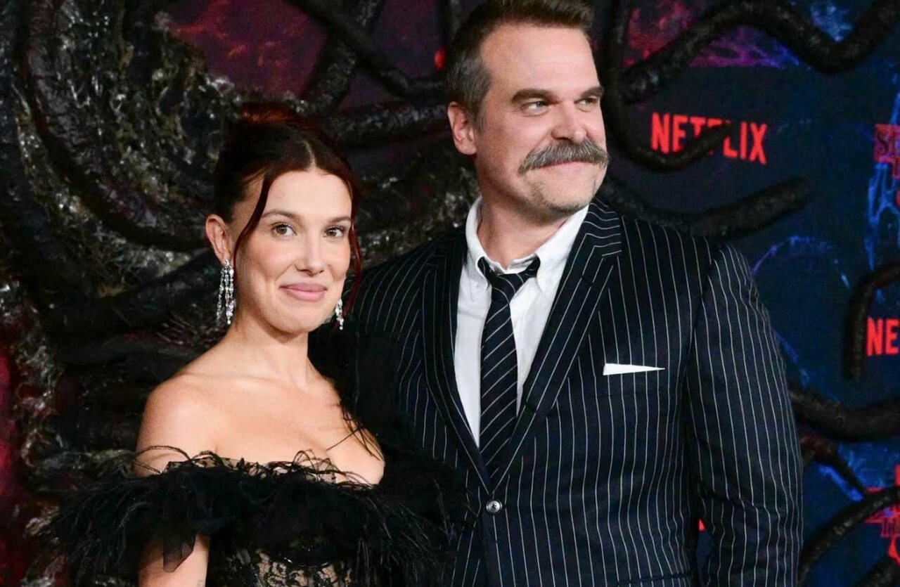 David Harbour and Millie Bobby Brown laughing together at Stranger Things Season 5 premiere.
