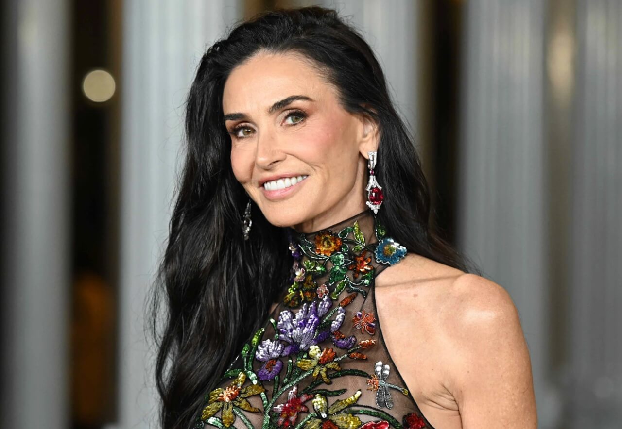 Demi Moore wearing layered sheer outfit and luxury earrings on Berlin red carpet.