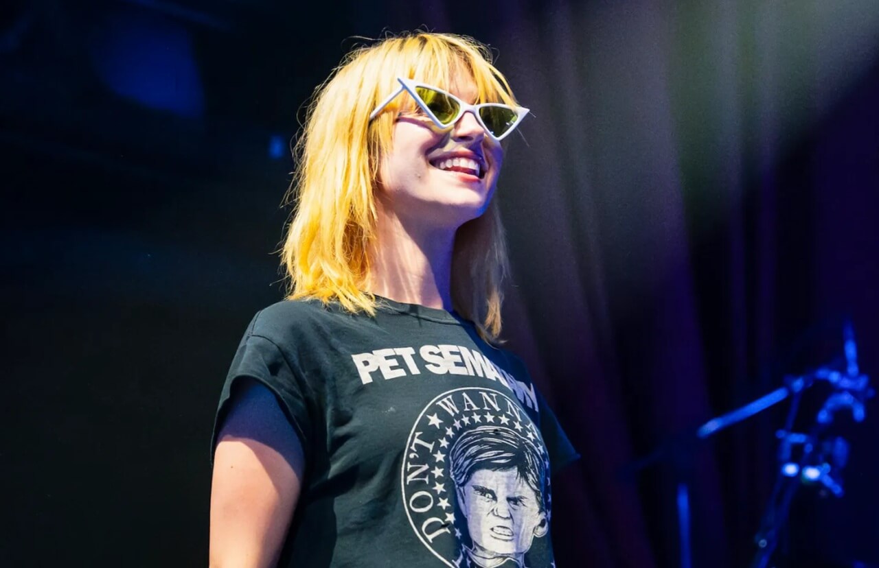 Hayley Williams performing live on stage with microphone.