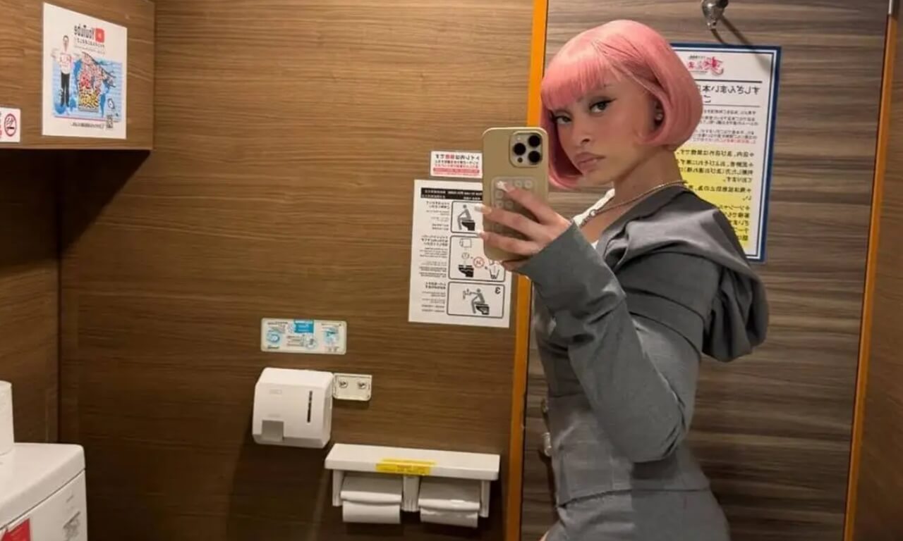 Ice Spice mirror selfie in grey mini dress with anime-inspired pink bob.