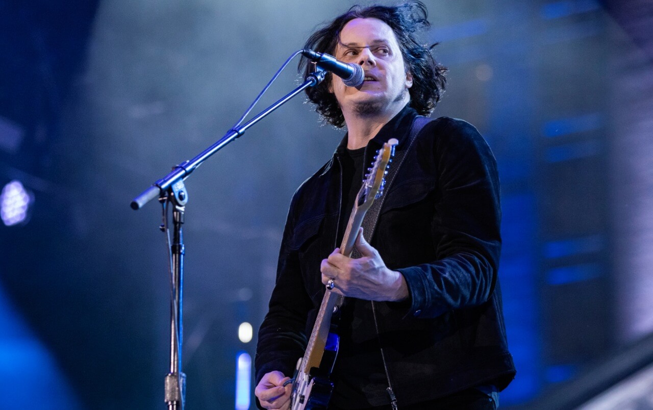 Jack White performing on the field during the Detroit Lions Thanksgiving halftime show at Ford Field.