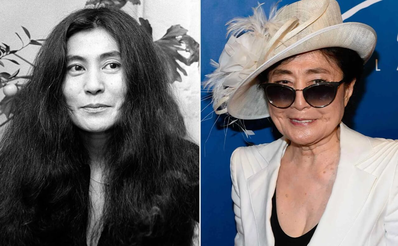 Yoko Ono standing at an outdoor art exhibit, smiling softly.