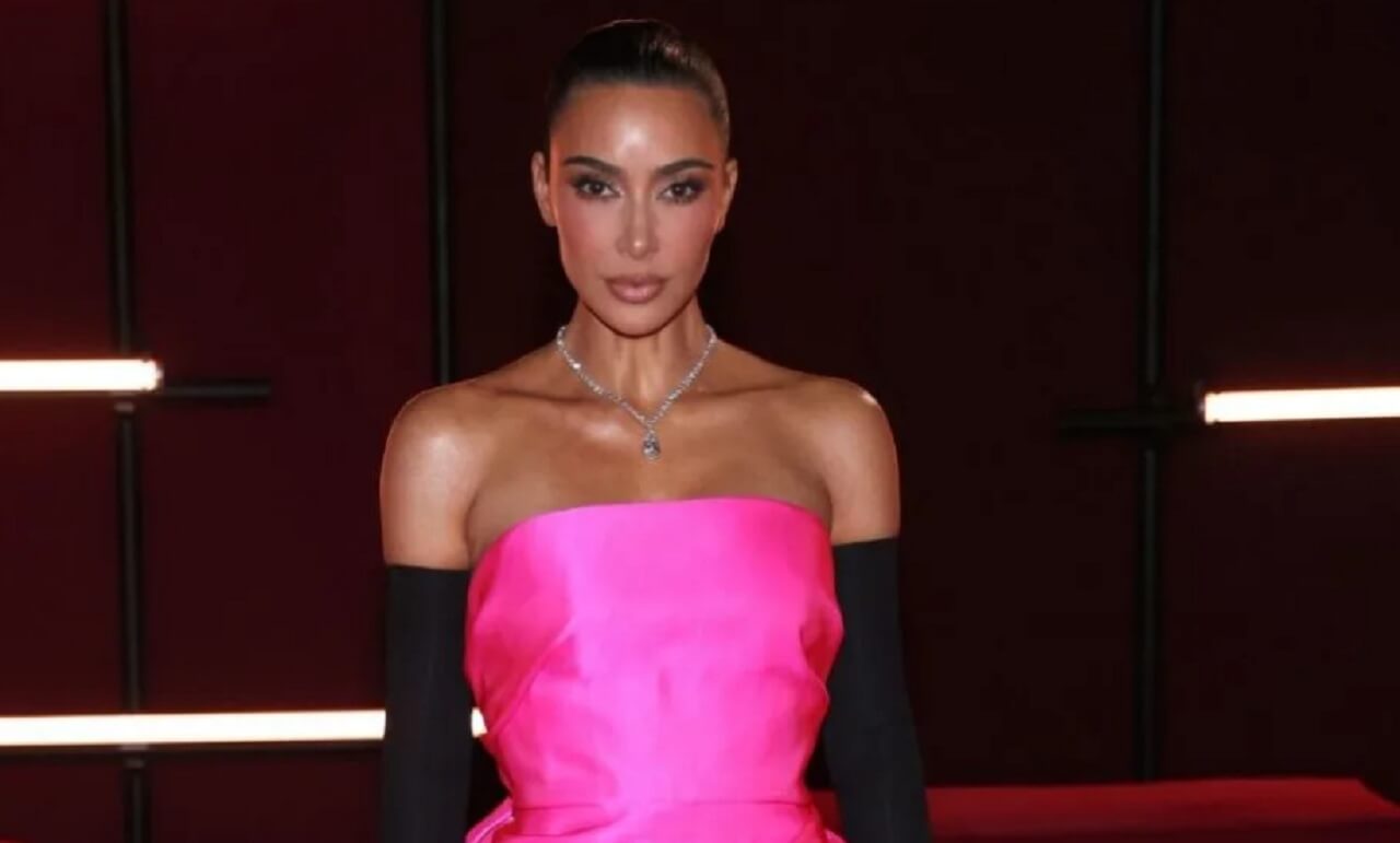 Kim Kardashian stuns in a hot pink sheer dress at Christ the Redeemer in Brazil, glowing under purple lights.