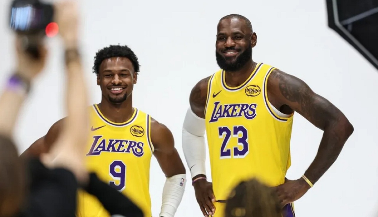 LeBron James smiling in the Lakers locker room while talking about his son Bronny James.