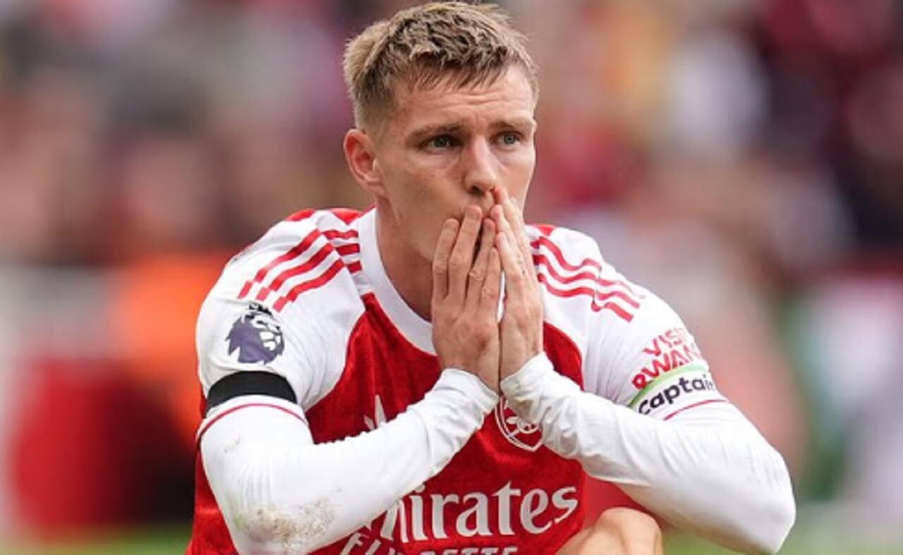 Martin Ødegaard on the pitch in Arsenal colors, sidelined due to injury as fans await his return.