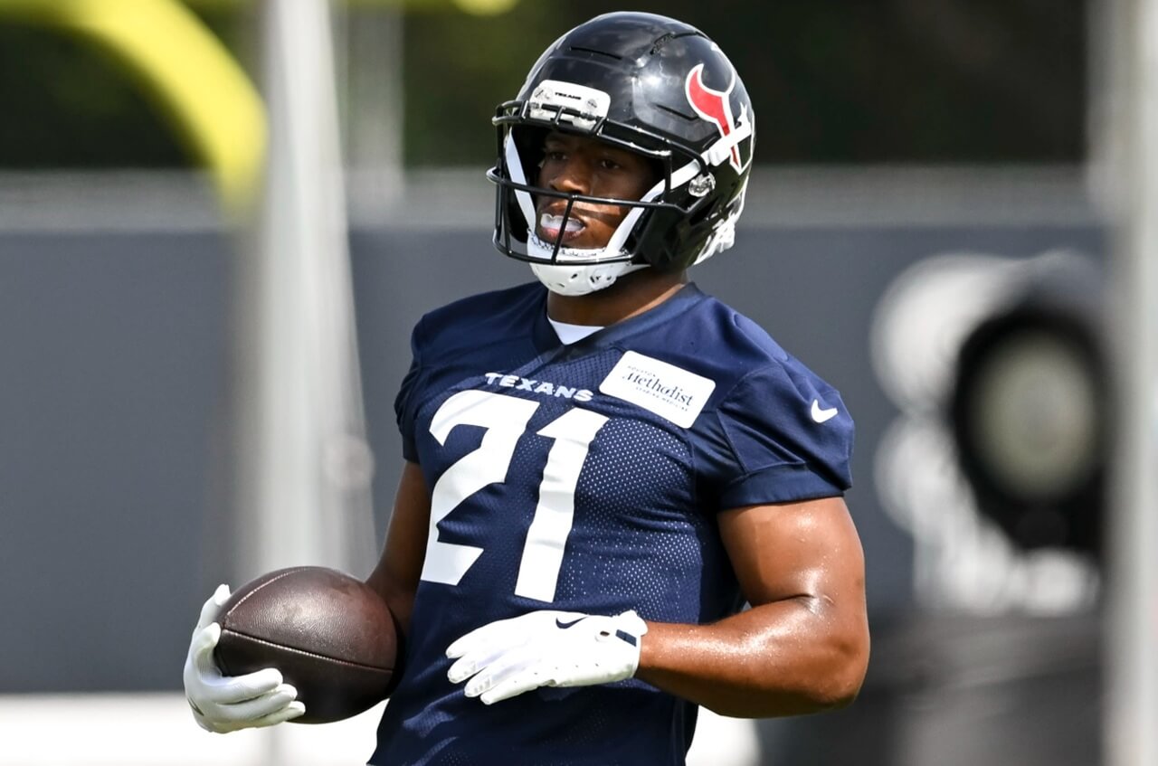 Nick Chubb running drills at Texans practice, in red practice jersey and helmet