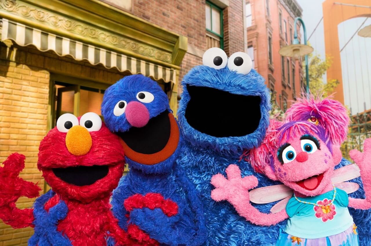 Sesame Street Season 56 cast with Elmo, Big Bird, and Cookie Monster on Netflix brownstone set.