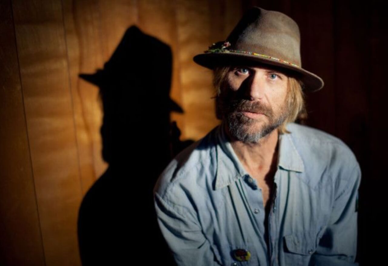 Todd Snider performing on stage with guitar