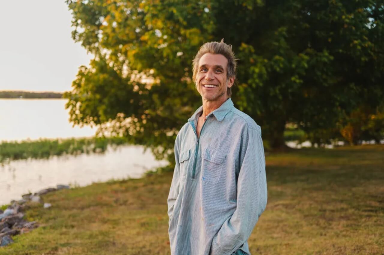 Todd Snider singing on stage with guitar before 2025 tour cancellation.