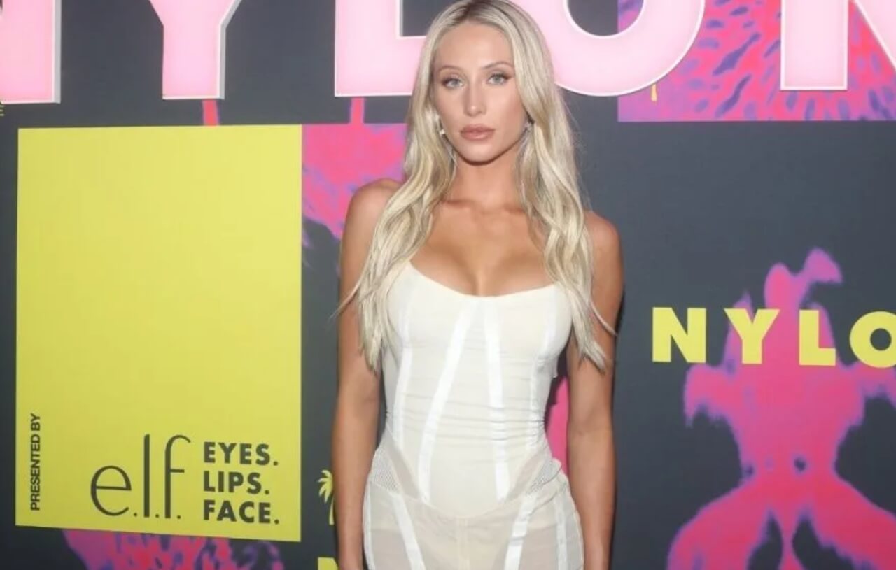 Ashtin Earle poses in swimwear and track pants during a beach outing.