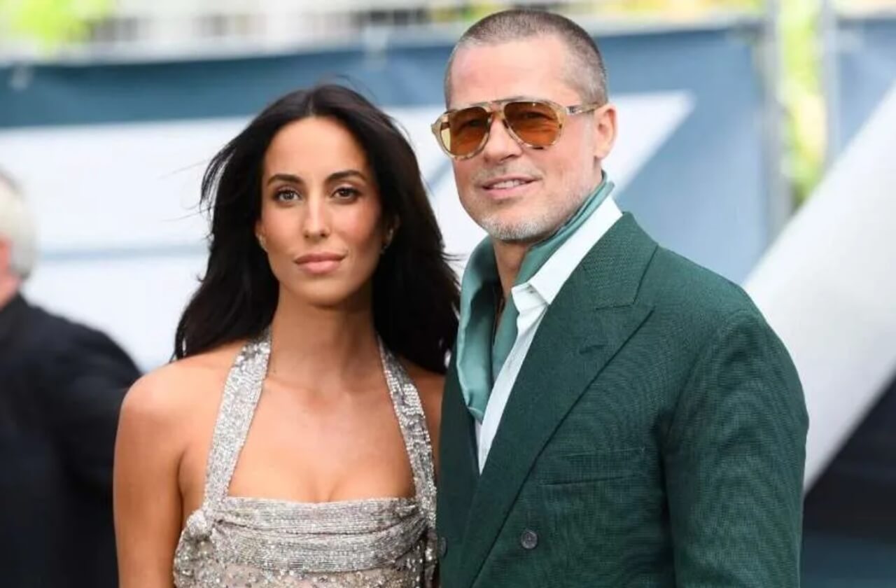 Brad Pitt attends a film premiere red carpet, smiling.