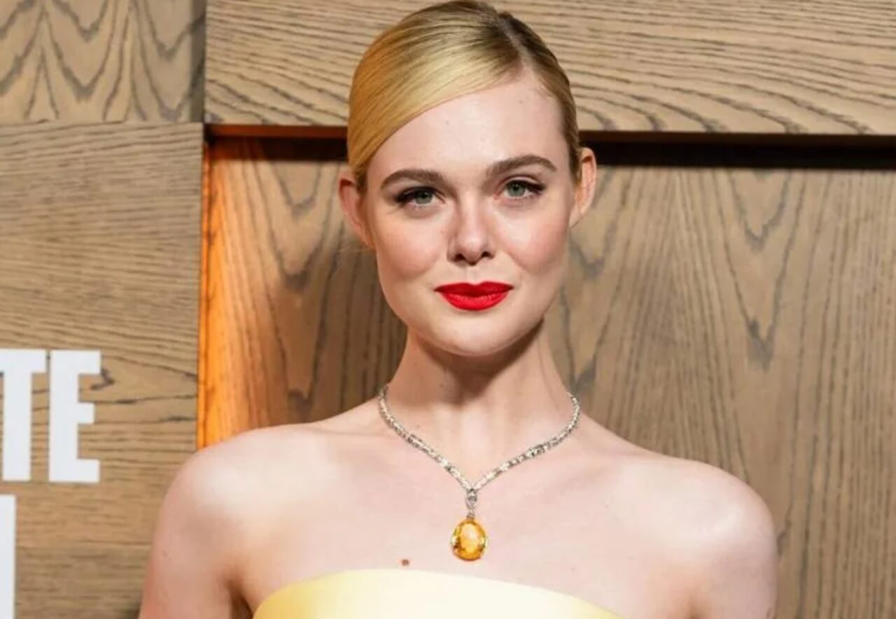 Elle Fanning wearing a yellow Givenchy gown with bold neckline and Cartier bracelet.