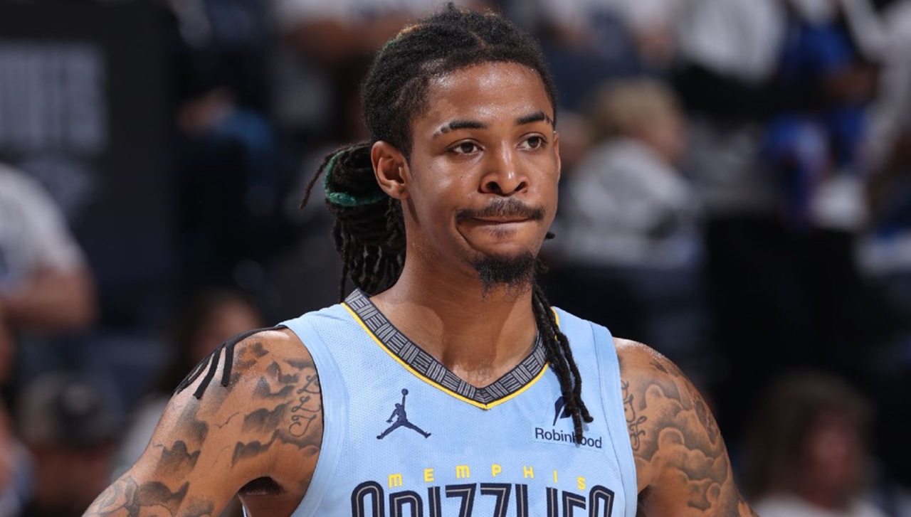 Ja Morant sits courtside in Memphis Grizzlies uniform while recovering from calf injury.