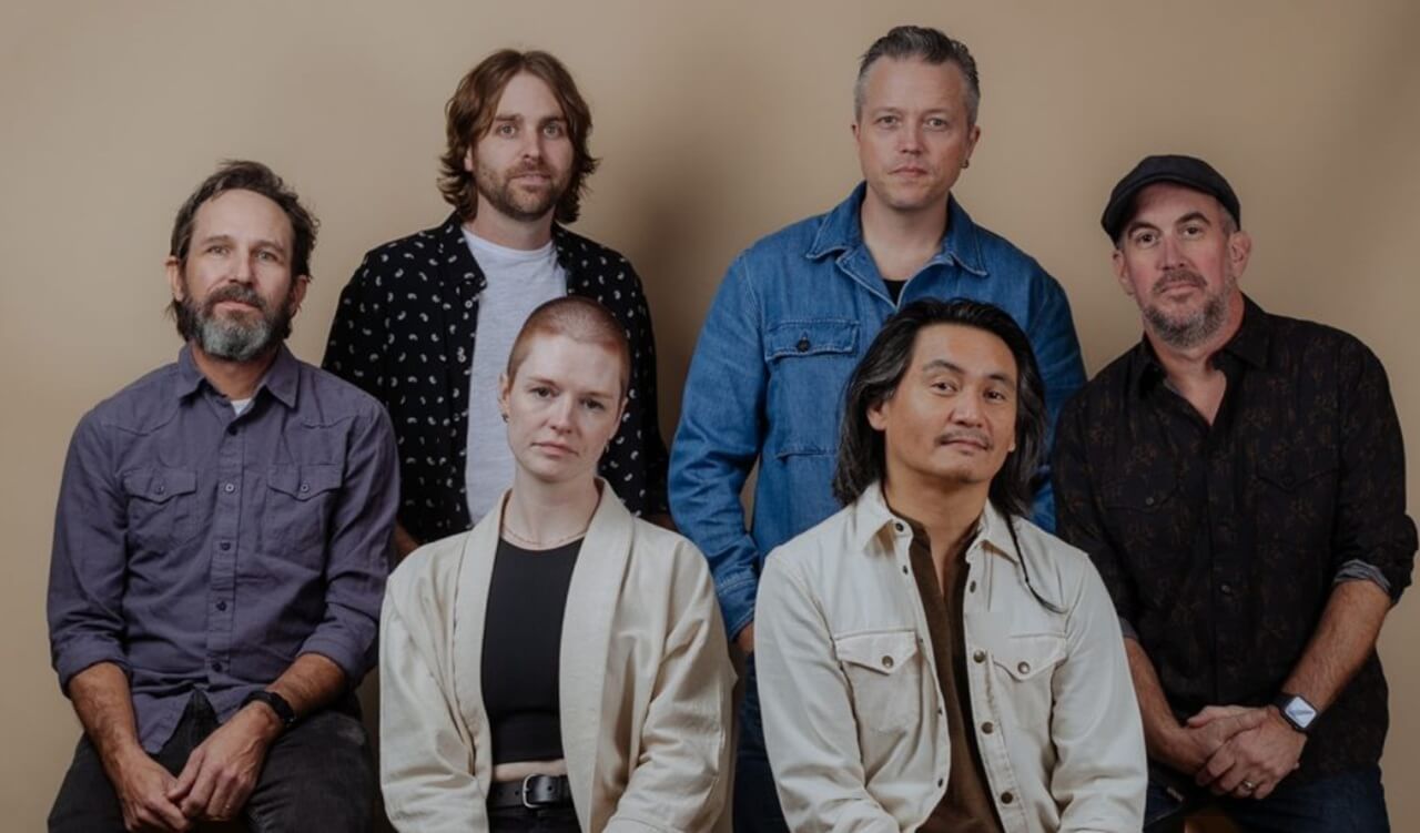 Jason Isbell plays guitar on stage with the 400 Unit during a live concert.