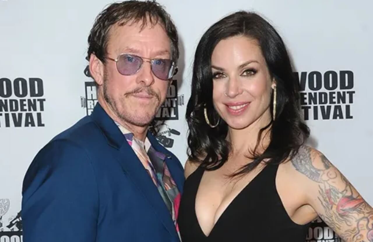 Scott Shriner and Jillian Lauren smile together at a 2019 film festival red carpet event.