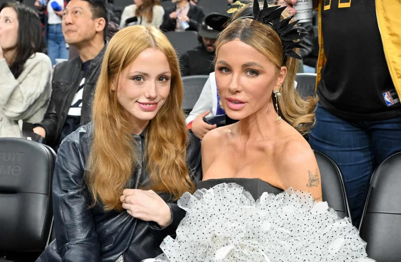 Kate Beckinsale and Lily Sheen seated courtside in contrasting outfits.