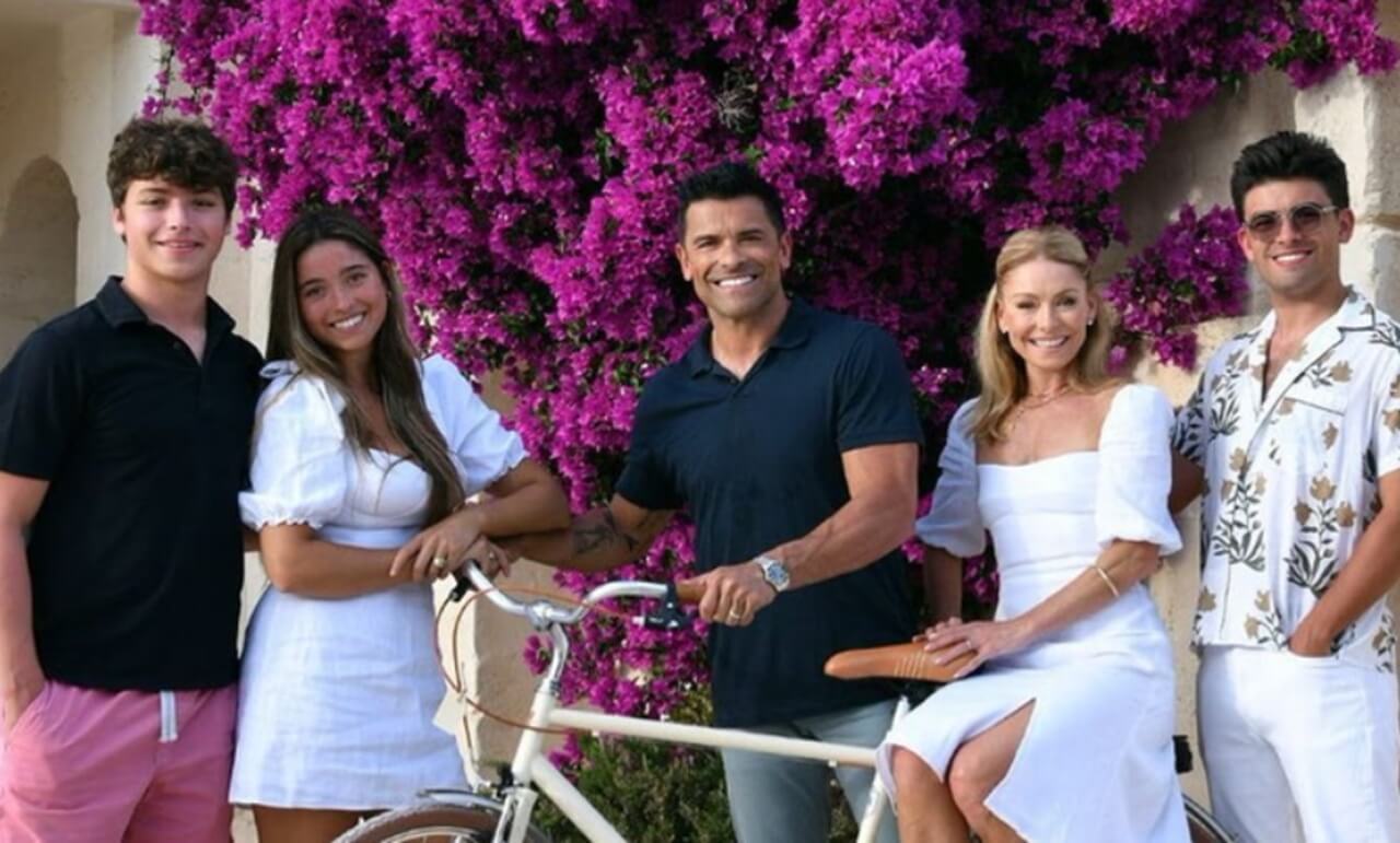 Kelly Ripa and Mark Consuelos posing with Dallas Cowboys Cheerleaders after announcing new Christmas card plan.