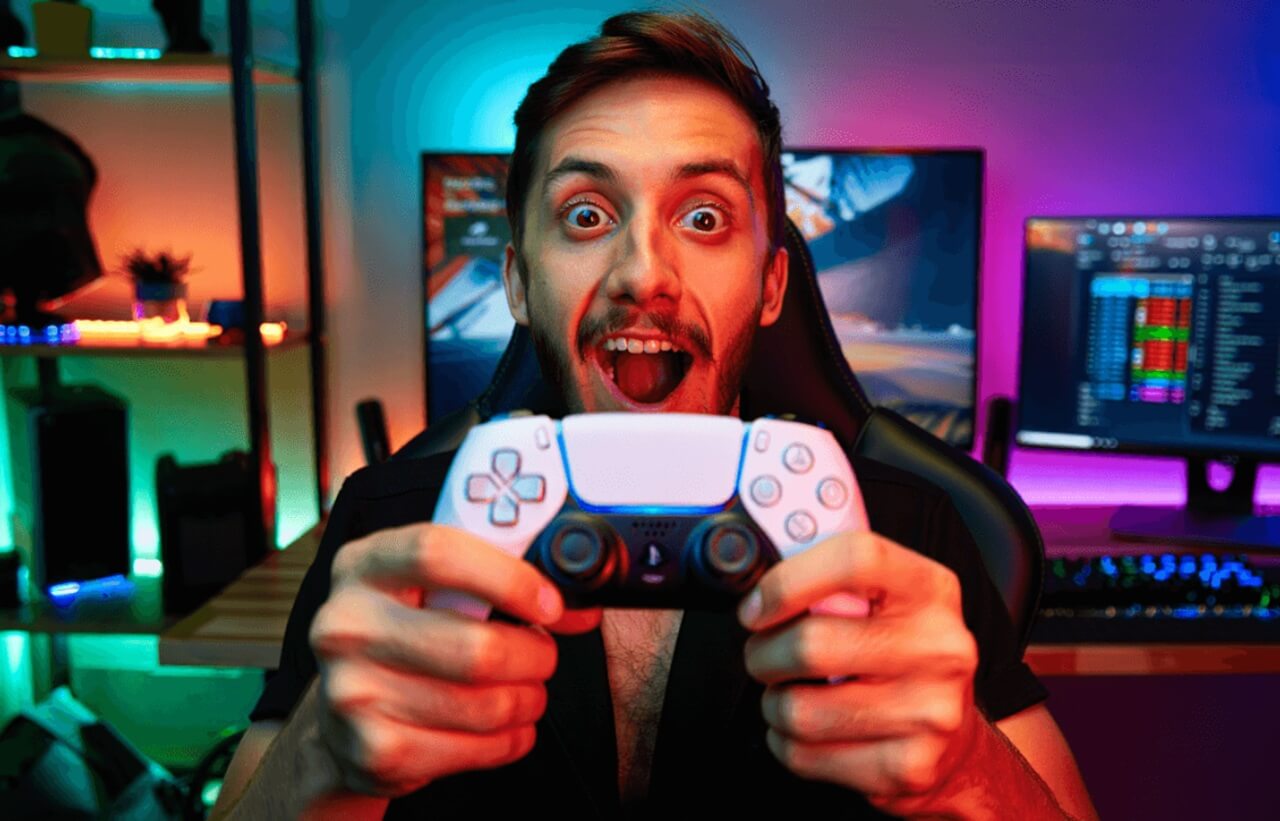 PS5 controller beside monitor displaying PlayStation Wrap Up 2025 gaming recap and exclusive avatar unlocks.