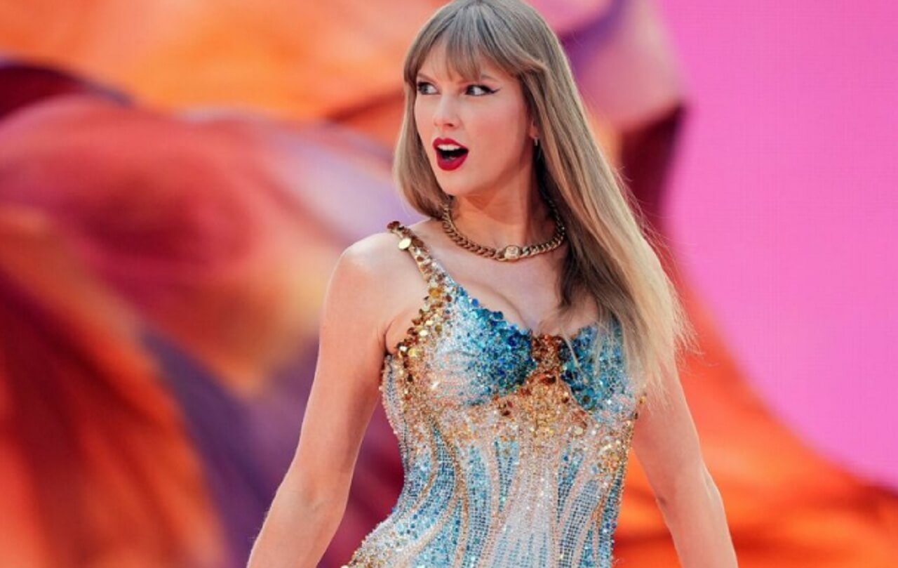 Taylor Swift performing during the Eras Tour with vibrant stage lighting and cheering fans.