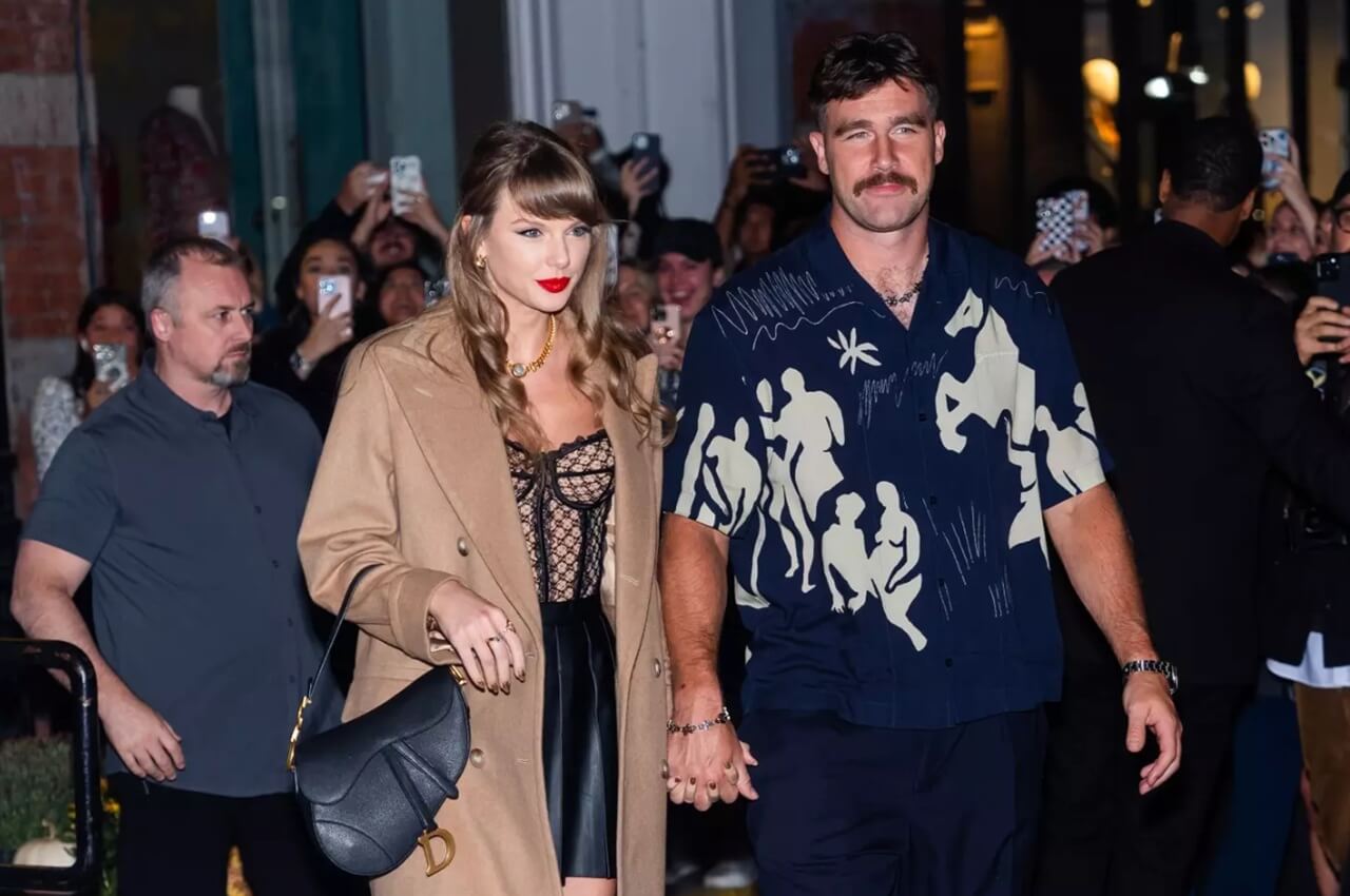 Travis Kelce and Taylor Swift pose together, smiling during a public outing