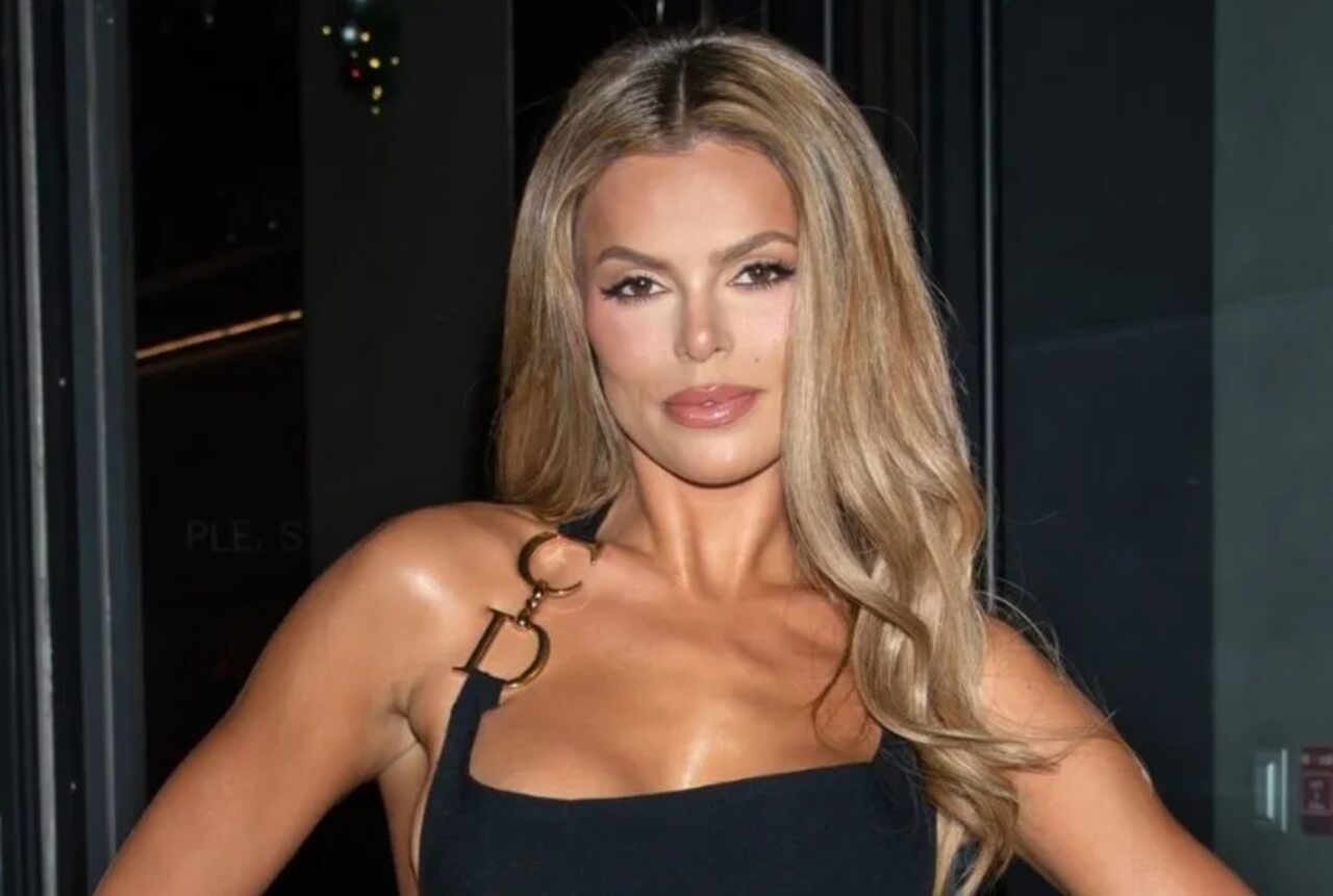 Brooks Nader poses in a chic red‑and‑white bikini with gold hoops and white sunglasses during her Cabo vacation.