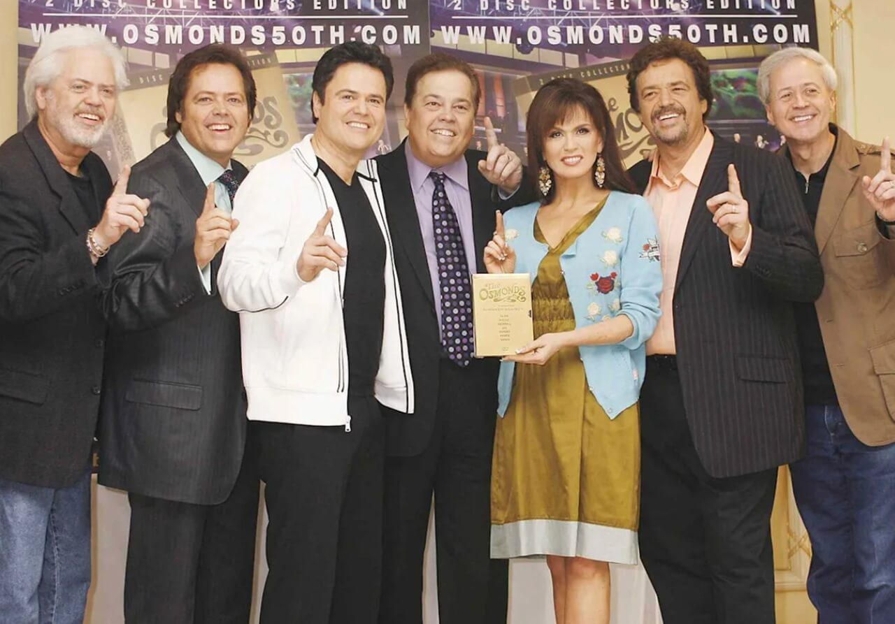 Donny and Marie Osmond with their seven brothers in a family photo.
