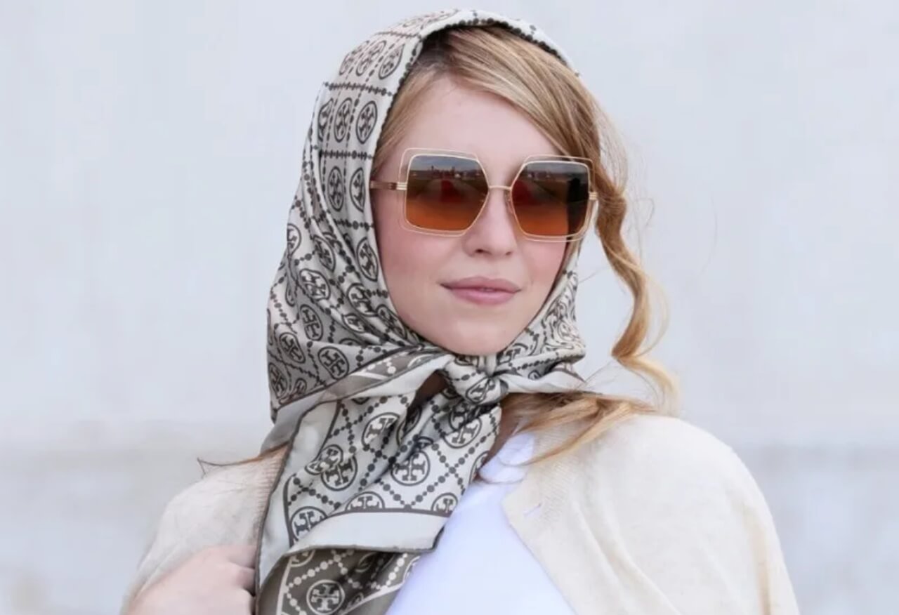 Sydney Sweeney wearing a puffer jacket minidress with a Dior scarf.