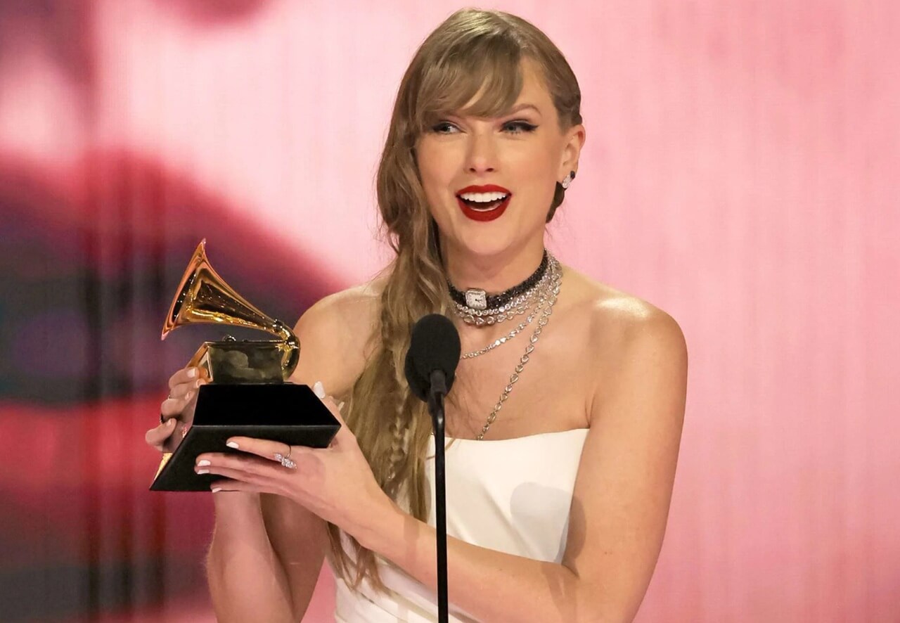 Taylor Swift accepts Album of the Year Grammy at 2024 ceremony.