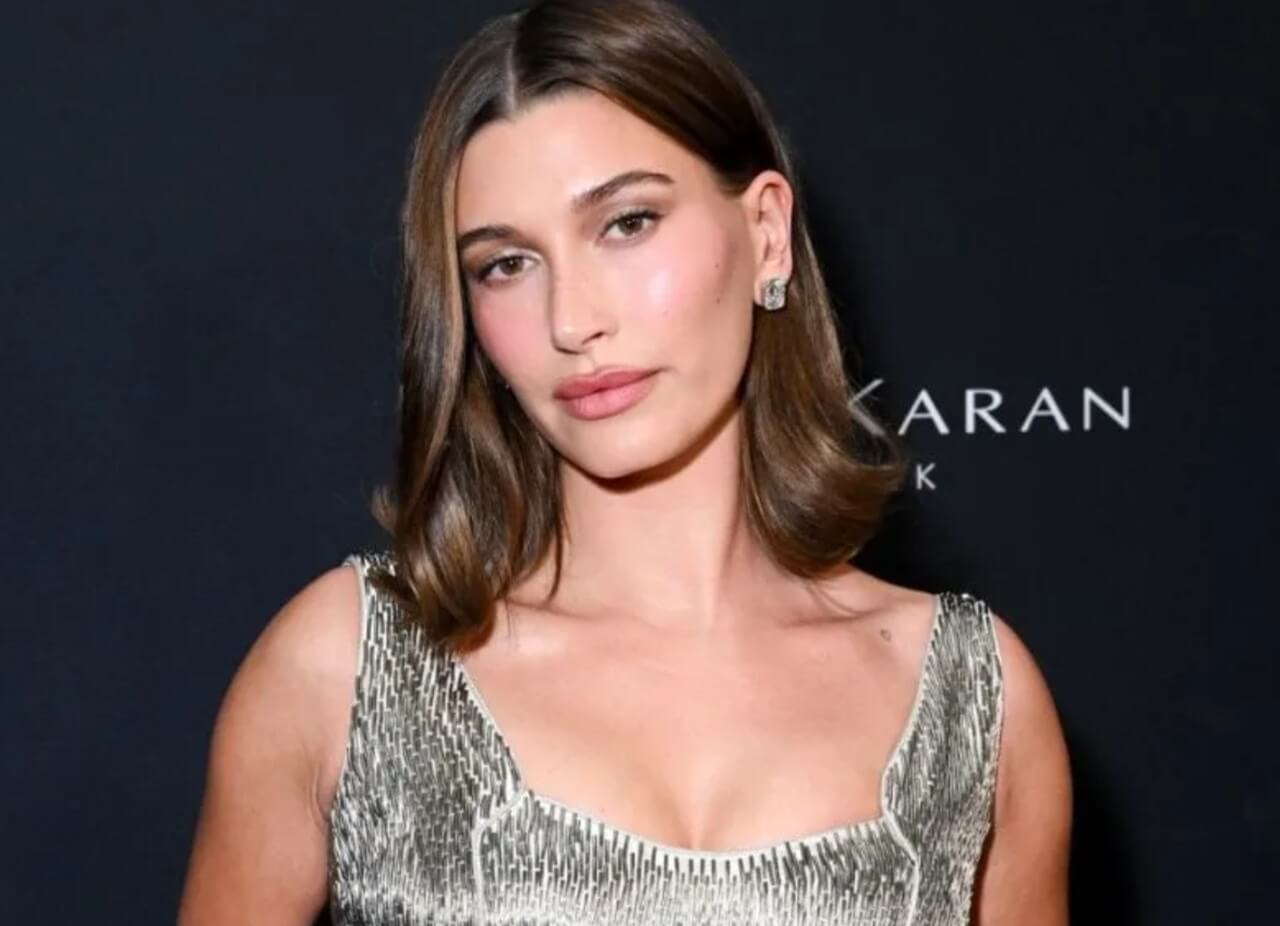 Hailey Bieber poses in white mini shorts and sweater for Rhode campaign in snowy mountains.