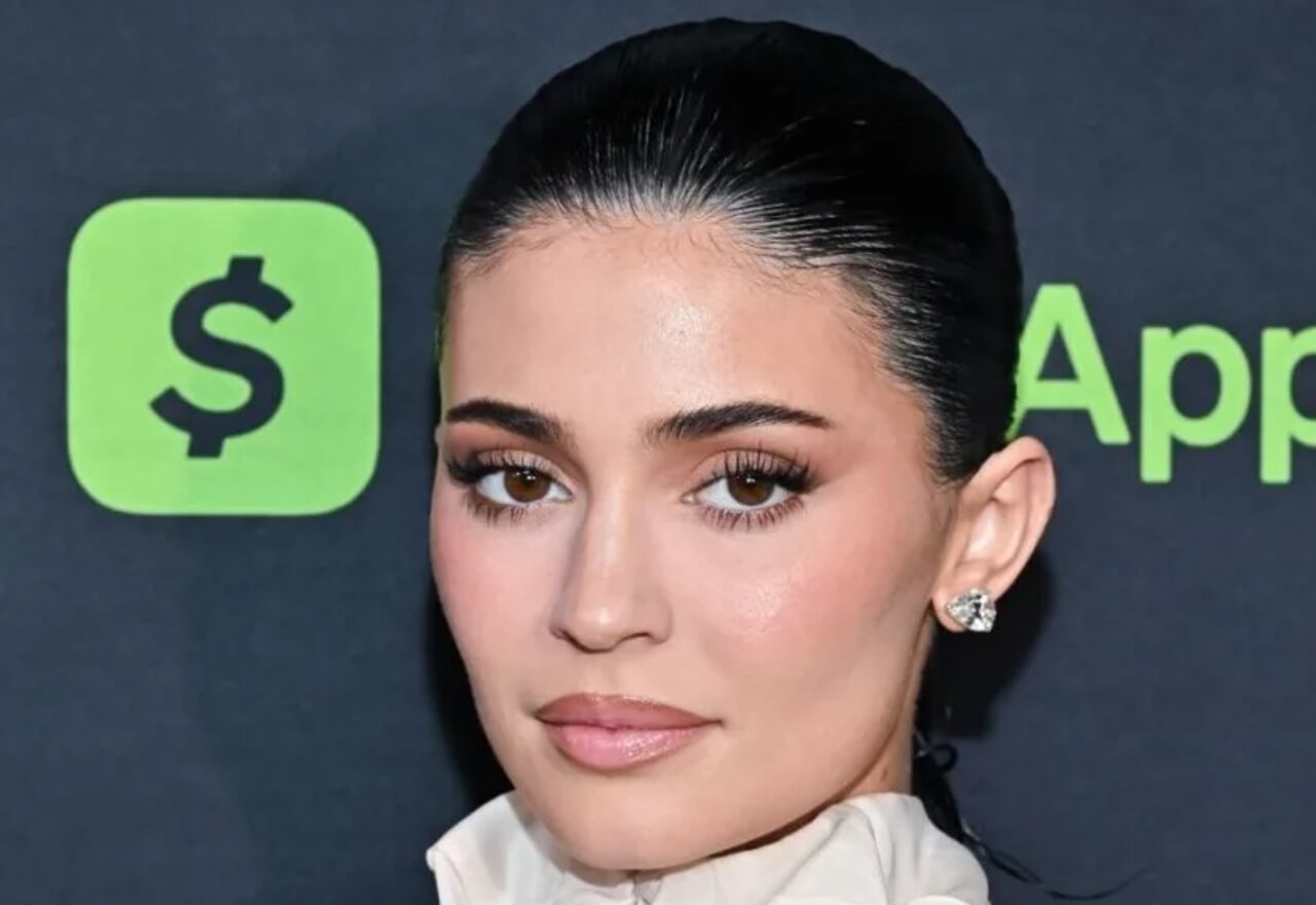 Kylie Jenner in bold crop top applying makeup in car after acting debut.