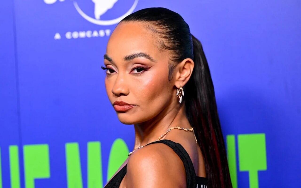 Leigh-Anne Pinnock performs live, smiling under bright stage lights.