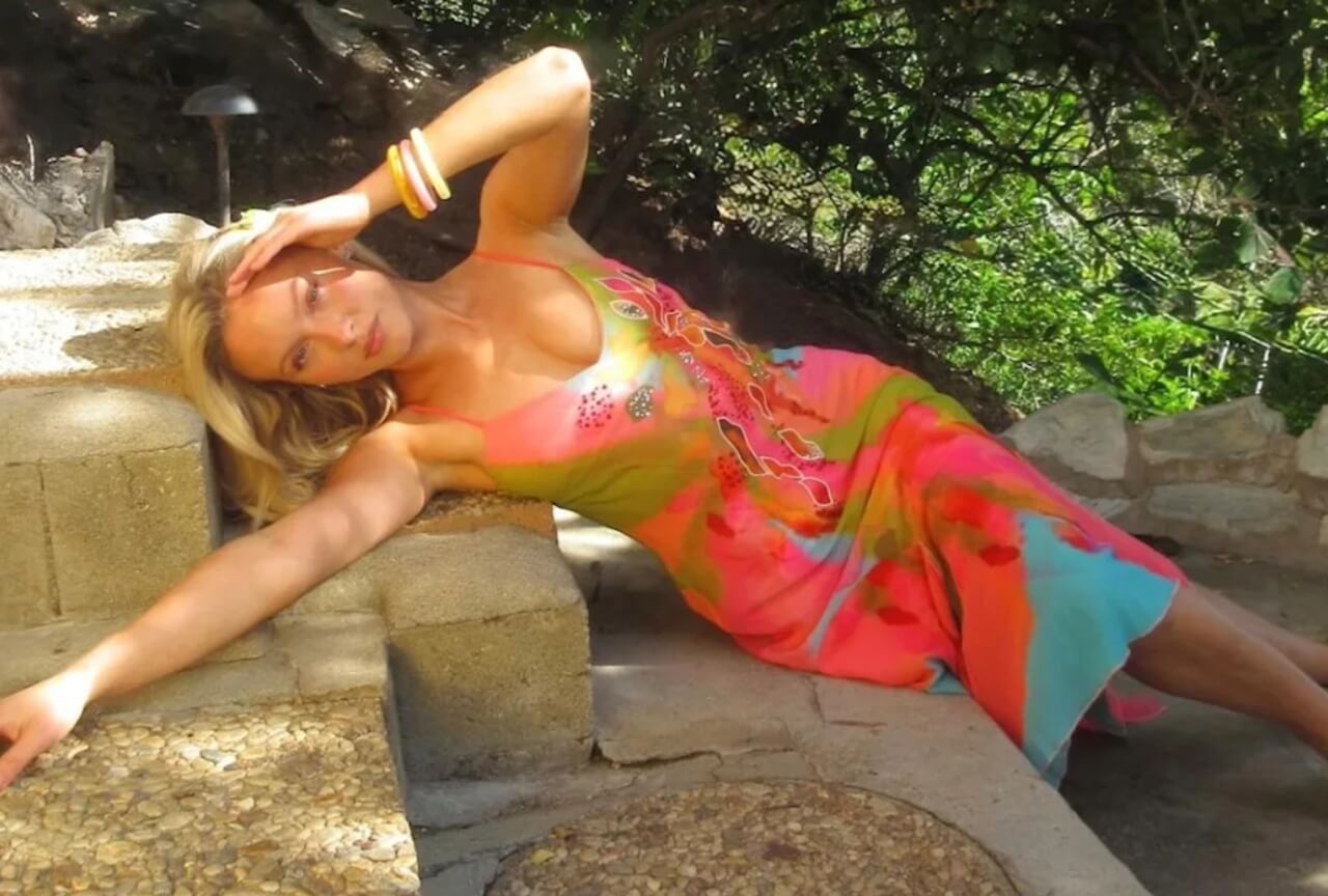 Zara Larsson in colorful floral dress with blonde waves and green hair clip.