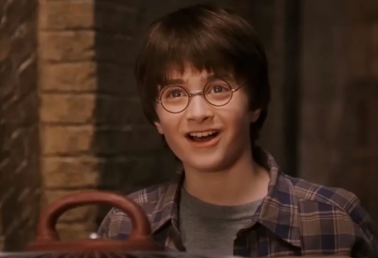 Daniel Radcliffe attends a premiere, smiling in a dark suit.