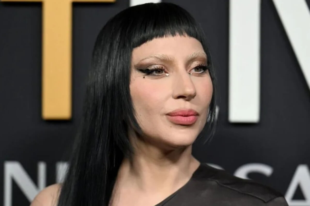 Lady Gaga commands the stage in a purple bodysuit and black coat during her Mayhem Ball concert in New York.