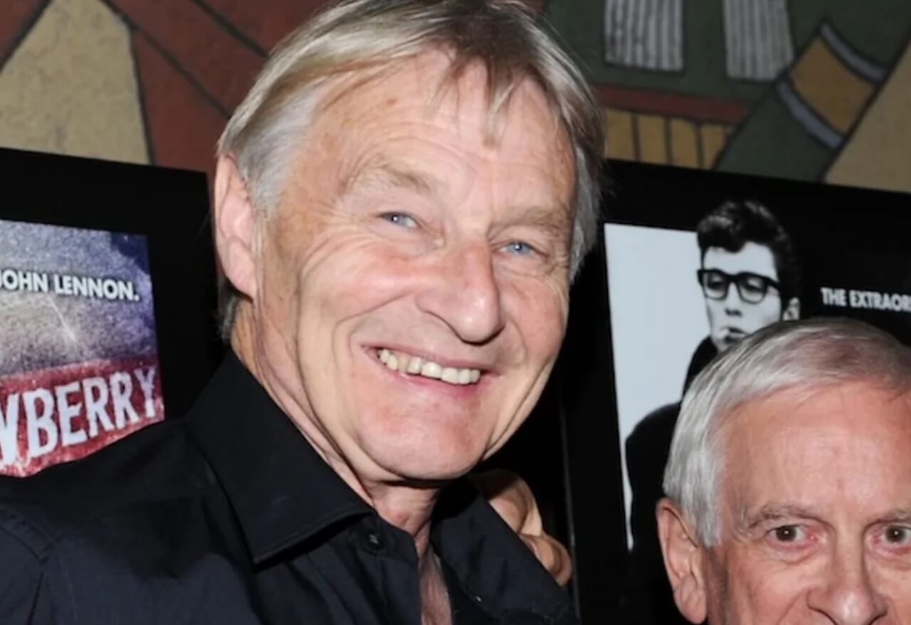 Len Garry plays guitar during a Quarrymen reunion performance.