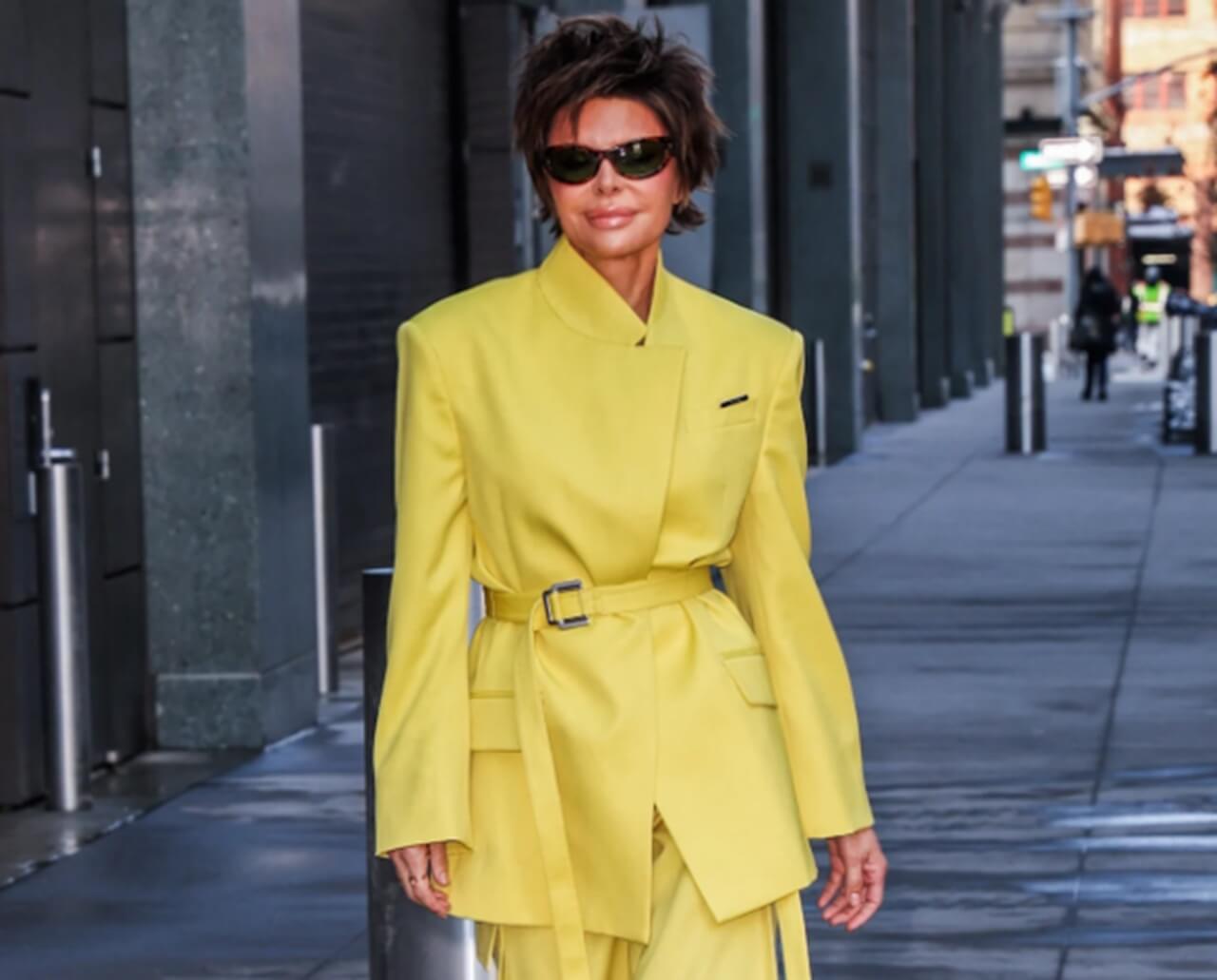Lisa Rinna in lemon yellow power suit with sunglasses and boots in New York City.
