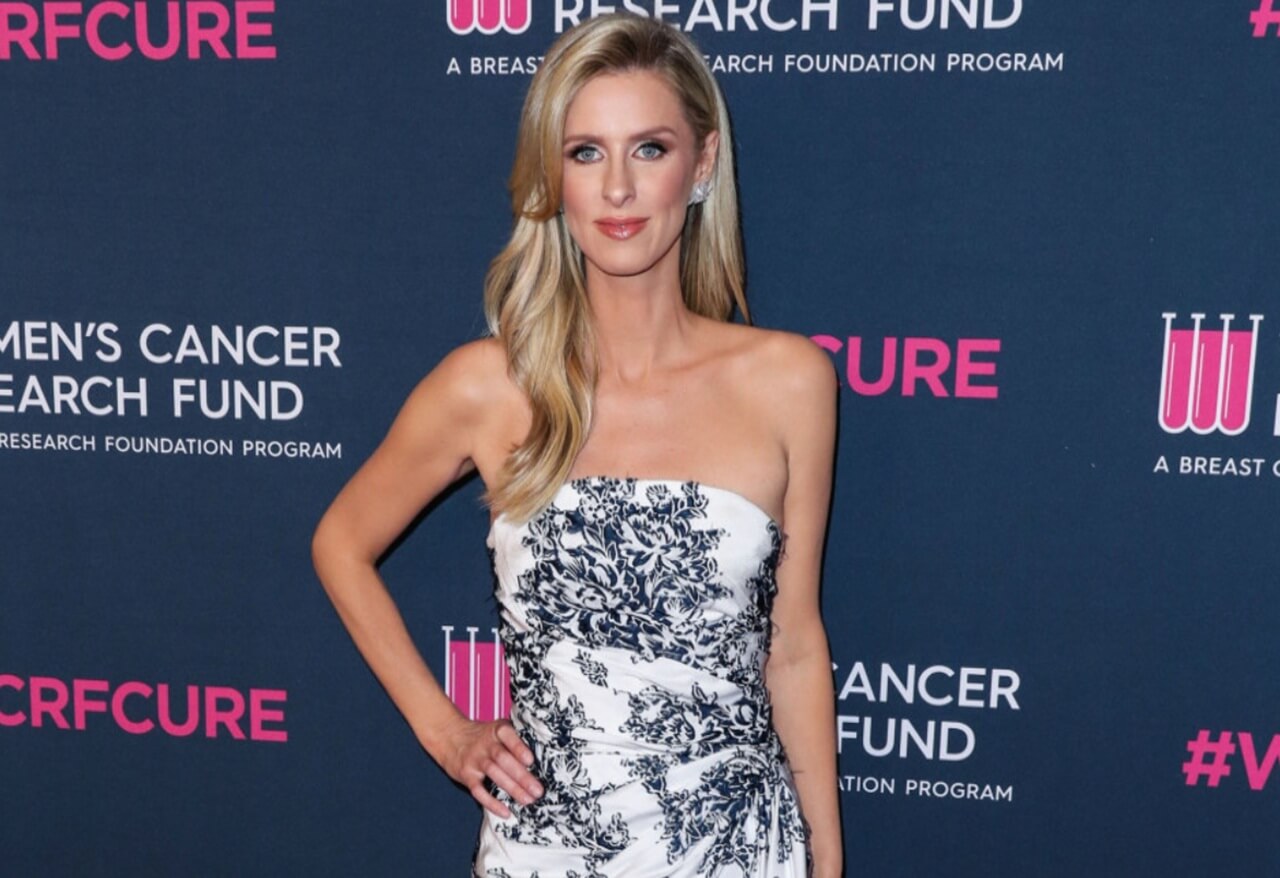 Nicky Rothschild in red and gold brocade minidress posing for mirror selfie in London.