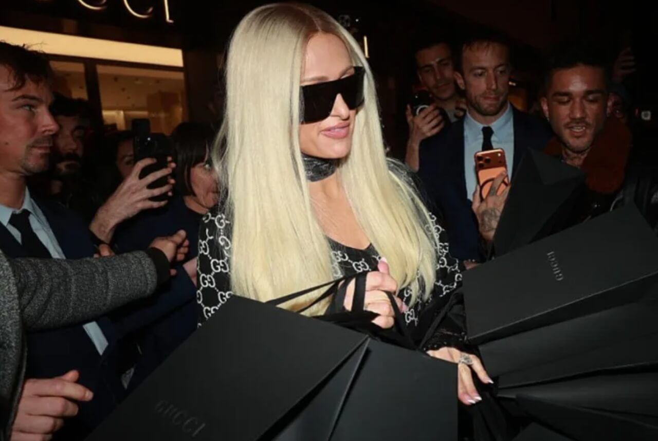 Paris Hilton in sheer white outfit with tiara and fur-trimmed jacket promoting Parívie.