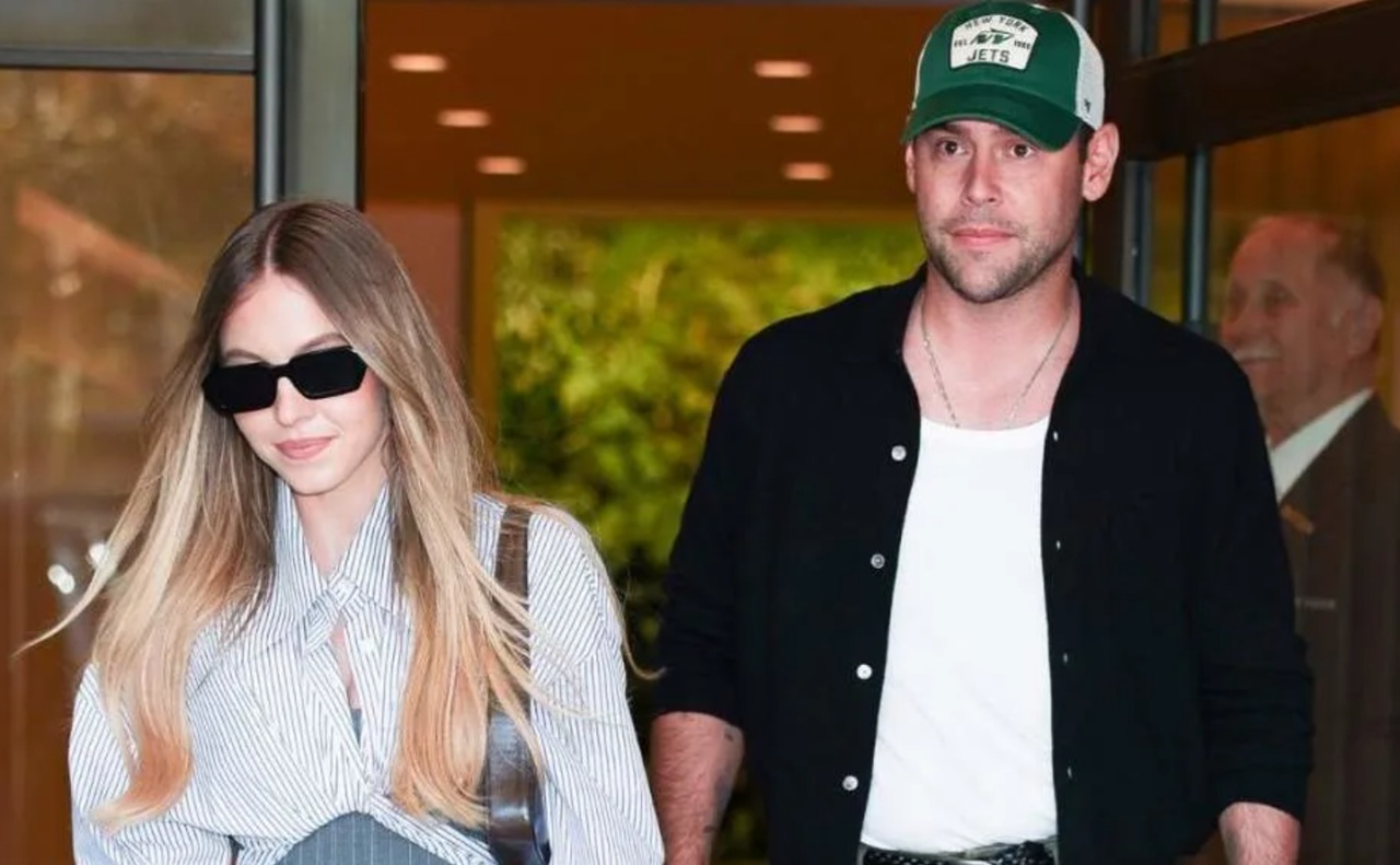 Scooter Braun and Sydney Sweeney together, smiling while walking outdoors.